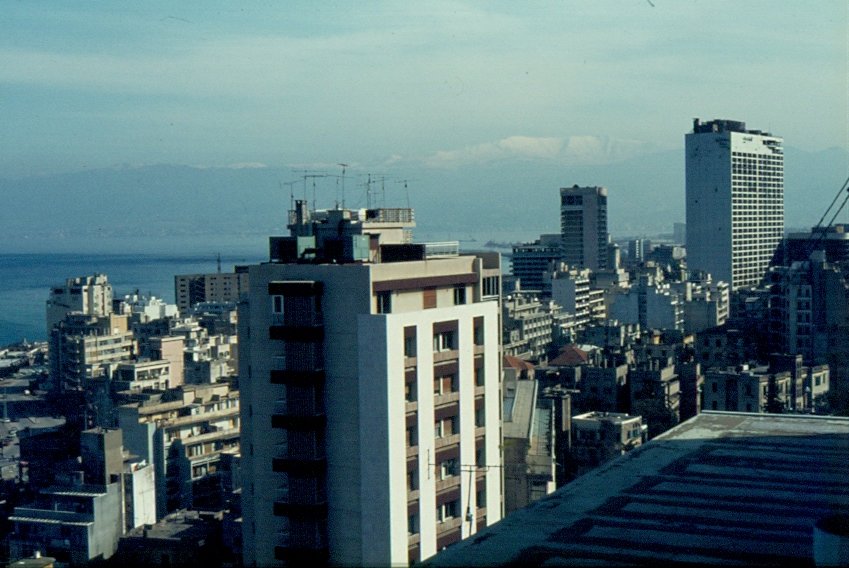 Im Januar 1983 gab es im Brgerkrieg im Libanon eine kurze Friedensphase. Zu diesem Zeitpunkt war ich in Beirut. Hier ein Blick ber die Stadt, den Hafen und das Schneebedeckte Libanon-Gebirge. Rechts im Bild das zerschossene und ausgebrannte ehemalige Hotel  Holiday Inn 