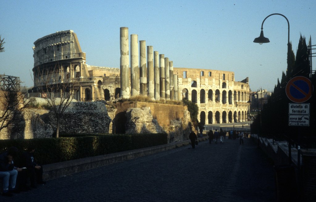 Roma / Rom 1989: Hinter den Ruinen des grssten Tempels in Rom, den Hadrian, Kaiser von 117 bis 138 n. Chr., fr die Gttin Venus und die vergttlichte Stadt Roma im Jahre 135 einweihen liess, sieht man das grsste Amphitheater, das schon in der Regierungszeit Vespasians vor der Vollendung eingeweiht wurde. Nachdem Vespasian 79 n. Chr. gestorben war, kam sein lterer Sohn Titus an die Macht. Er liess 80 n. Chr. das Amphiatheater zum zweiten Mal einweihen. 