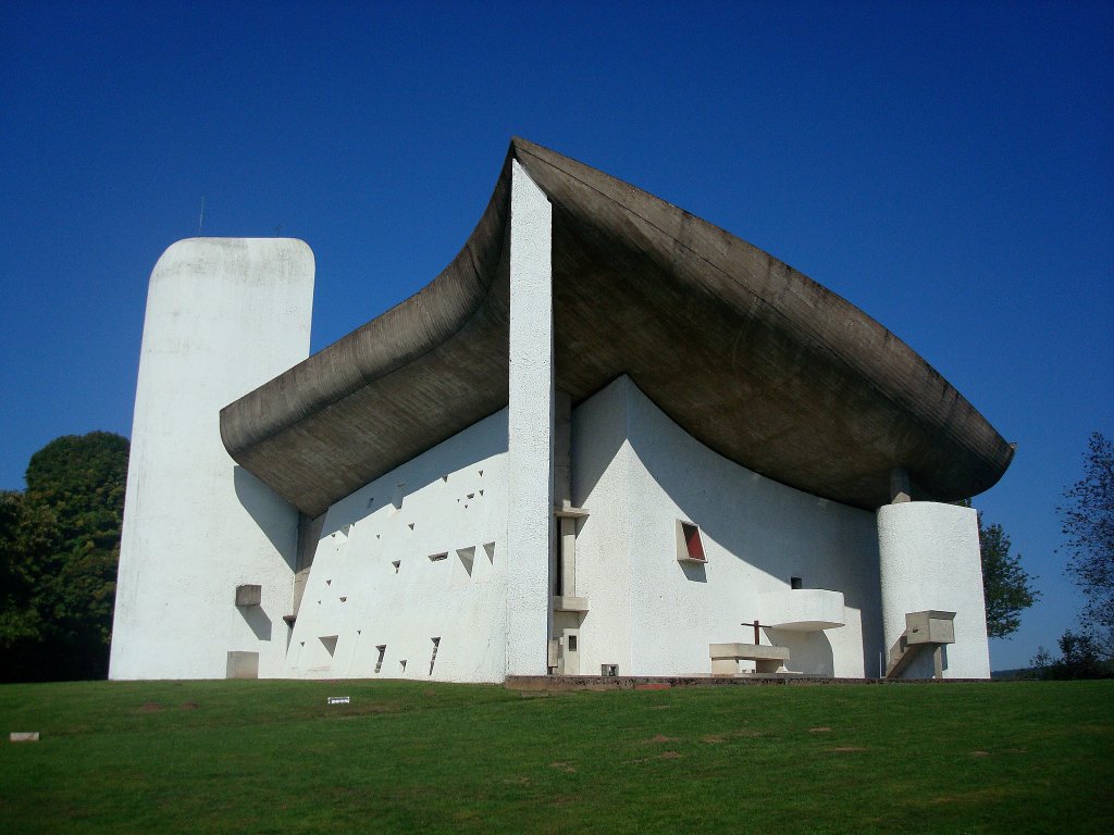Wallfahrtskirche in Ronchamp / Frankreich,
erbaut vom Schweizer Le Corbusier (1887-1965), bedeutender Architekt, Maler, Bildhauer, Stadtplaner und Designer,
Bauzeit 1953-55, hier ist die Sdseite mit Turm und die Ostseite zu sehen,  Sept.2010
