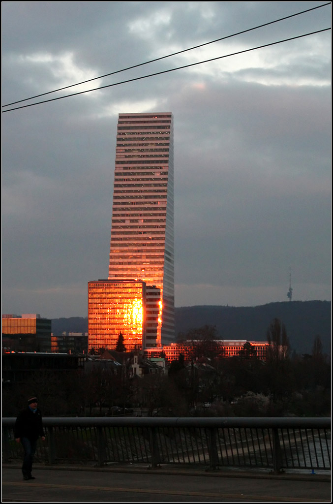 . Die Roche Hochhuser reflektieren den Sonnenuntergang -

Das alte Hochhaus von Roche wirkt winzig im Gegensatz zum Neubau. Blick von der Wettersteinbrcke in Basel auf die beiden Gebude. Rechts oben auf dem Berg ist der Fernsehturm St. Chrischona zu erkennen.

14.03.2016 (M)
