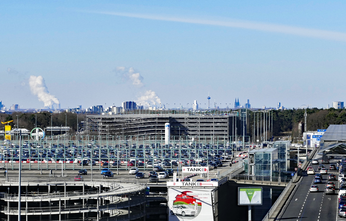 Aufnahme vom Flughafen Kln/Bonn ber die Parkhuser zur Skyline von Kln, mit qualmenden RWE-Kohlekraftwerken, dem Fernsehturm und dem Klner Dom. 25.02.2018