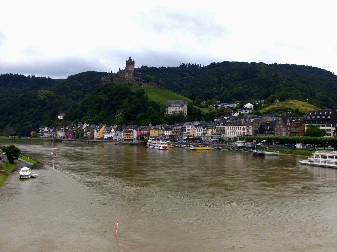 Blick auf die Stadt, die leicht berflutete Mosel und die Reichsburg in Cochem. Wo das Boot im linken Bereich schwimmt, wre normalerweise ein Fu- bzw. Fahrradweg. [Ende Juni 2016]