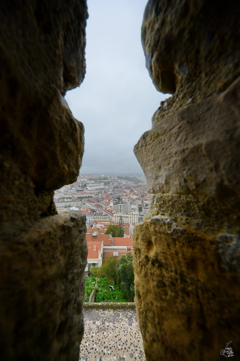 Blick durch eine der Schie- und Beobachtungsscharten der Festungsanlage Castelo de So Jorge auf das Zentrum der portugiesischen Hauptstadt Lissabon. (Dezember 2016)