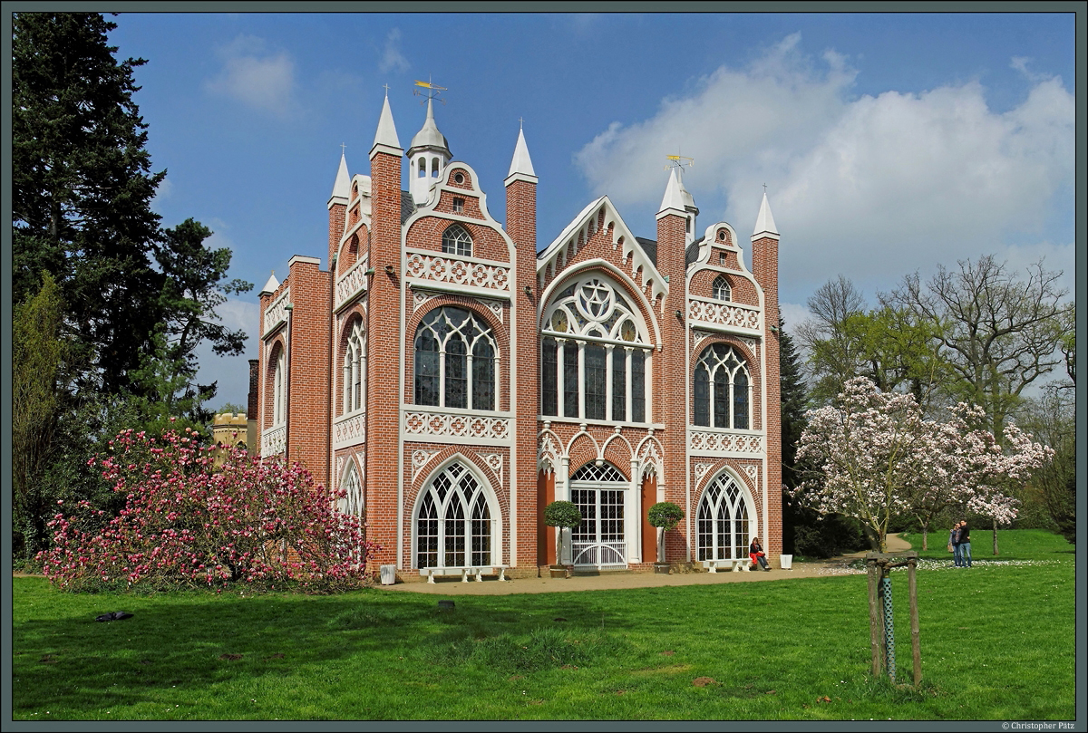 Das 1773 bis 1813 errichtete Gotische Haus ist einem englischen Landsitz nachempfunden. Das zum Wrlitzer Park gehrende Gebude wird am 06.04.2014 von blhenden Rhododendronbschen flankiert.