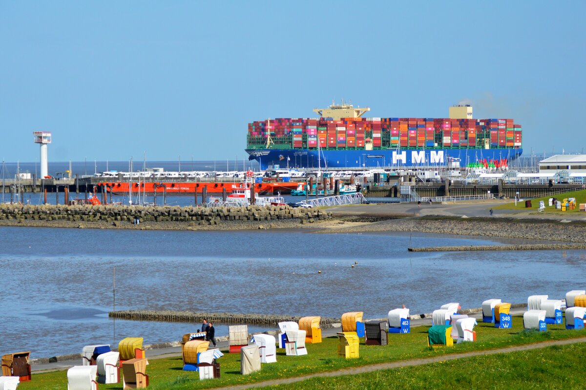 Der Containerfrachter HMM Southampton ist auf dem Weg von Hamburg nach Tanger in Marokko und passiert den Strand und die Hafenanlage in Cuxhaven Grimmelshrn. (Mai 2022)
