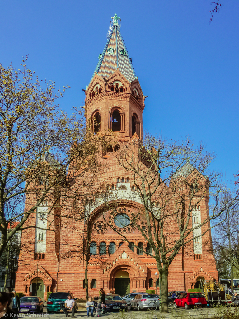 Die Passionskirche in Berlin-Kreuzberg wurde 1905 - 1908 im neuromanischen Stil mit quadratischem Grundriss erbaut. In der Mitte des Backsteinbaus befindet sich der Turm mit verschieden farbig glasierten Dachziegeln. (30.03.2014)