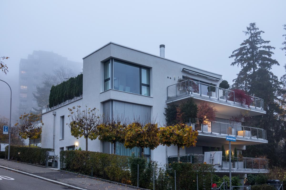 Ein modernes Haus im vorgrund und das Waldhaus Dolder im Hintergrund in Nebel  gekleidet . November 2018, Zrich.