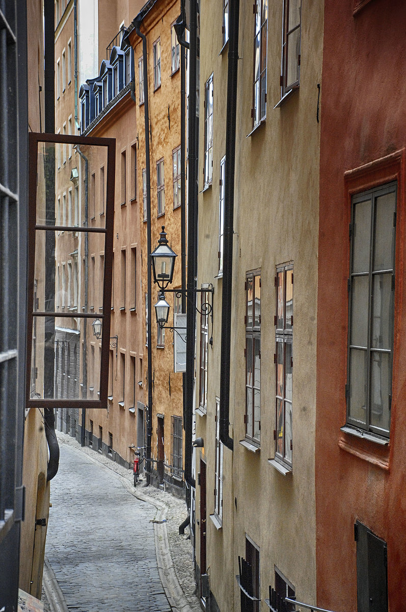 Gasse in der Altstadt (Gamla Stan) von Stockholm. Das heutige Gamla stan war in frheren Jahrhunderten das eigentliche Stockholm. Die ersten Huser entstanden im 13. Jahrhundert, die ltesten Straen sind Kpmangatan, erstmals erwhnt 1323
Aufnahme: 25. Juli 2017.