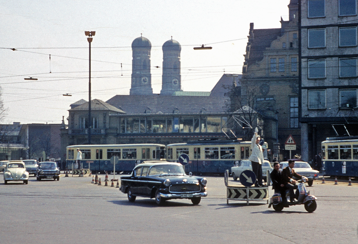Historische Aufnahme vom Lenbachplatz in Mnchen (1962). Der Verkehr wird noch von  Schupos  und nicht von Ampeln geregelt. Hinter der Straenbahn das  Knstlerhaus  und im Hintergrund die  Frauenkirche . (Scan vom Dia). 