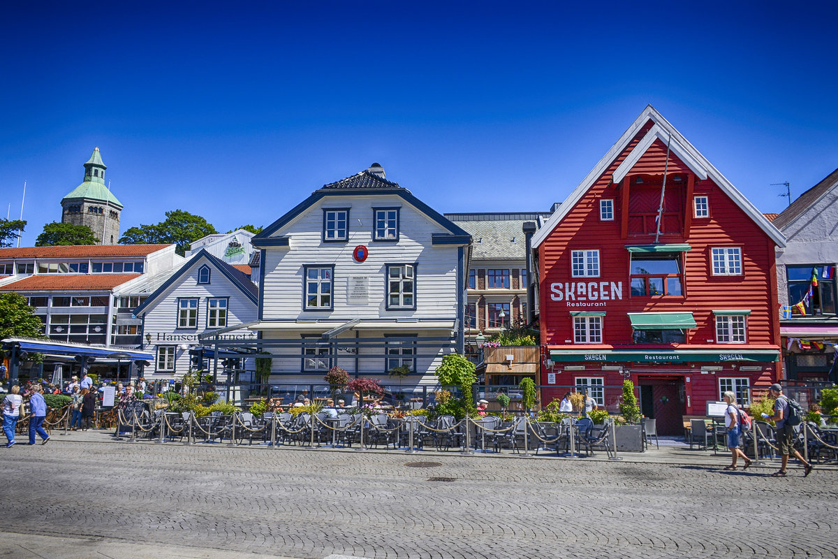 Holzhuser am Skagenkaien in der norwegischen Hafenstadt Stavanger. Links im Bild ist der Valberstrnet zu sehen. Das weisse Haus beherbergt das dnische Konsulat. Im roten Haus rechts ist das Restaurant Skagen. Aufnahme: 3. Juli 2018.