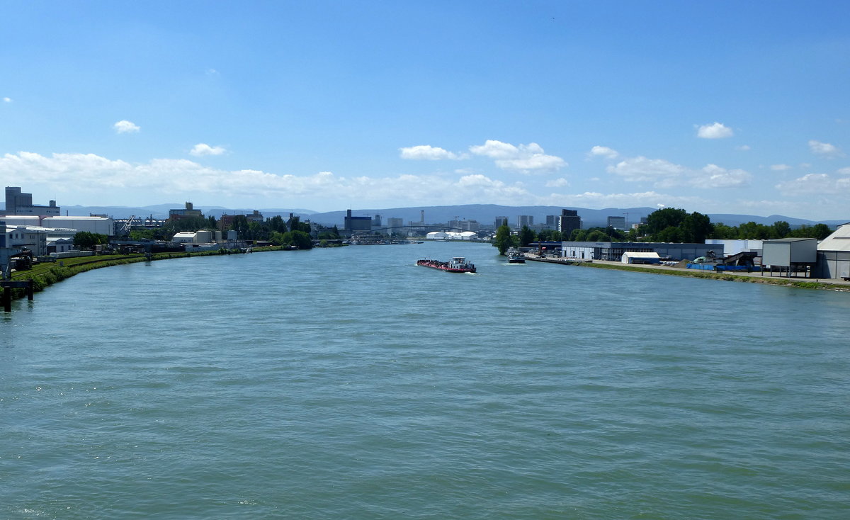 Hningen (Huningue), Blick von der Palmrainbrcke ber den Rhein fluaufwrts Richtung Basel, mit vielen Industrieanlagen auf der deutschen Seite(links) und auf der franzsischen Seite(rechts), am Horizont die Berge der Schweizer Jura, Juli 2016