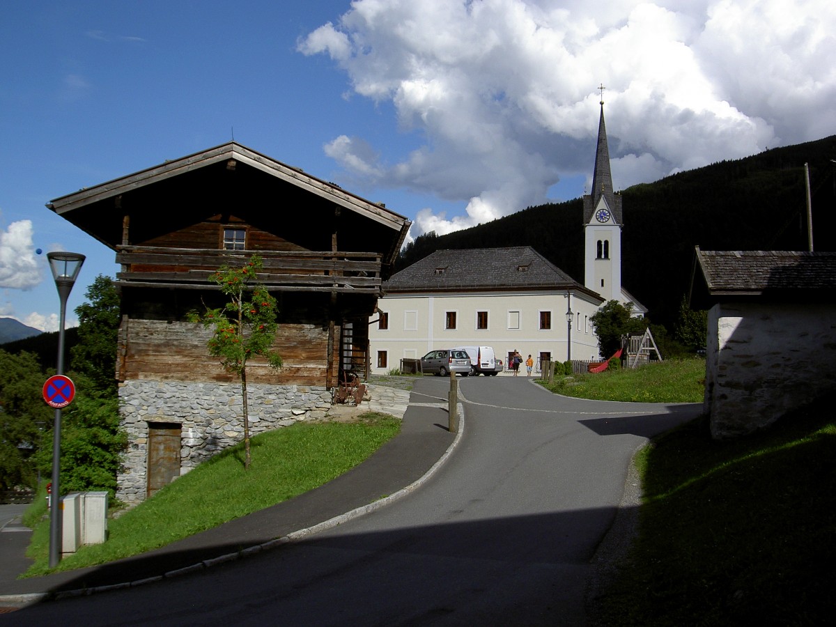 Kaprun, Pfarrkirche St. Margarethe und Holzhaus des Heimatmuseums am Kirchplatz (01.08.2014)
