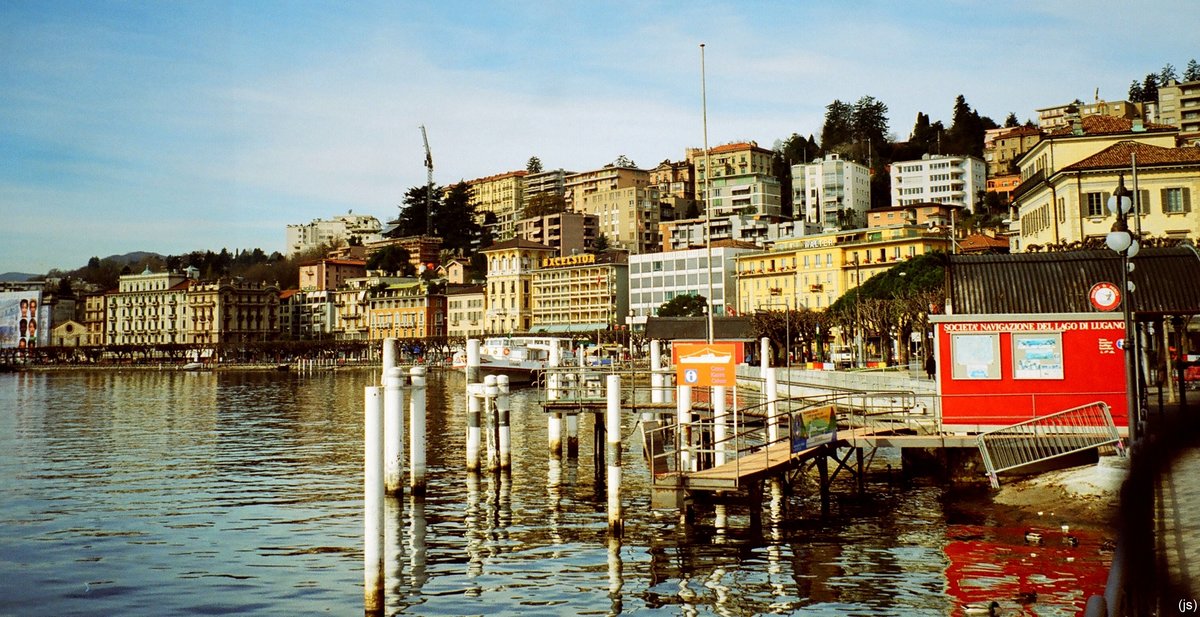 Lugano, die grte Stadt des Tessins und damit Zentrum der ganzen Italienischen Schweiz, die nebenbei gesagt nicht nur aus dem oben erwhnten Kanton besteht, liegt herrlich an einer Bucht des gleichnamigen Sees. Auf dem Bild vom Mrz 2000 ist Uferpromenade des Lago di Lugano zu sehen.