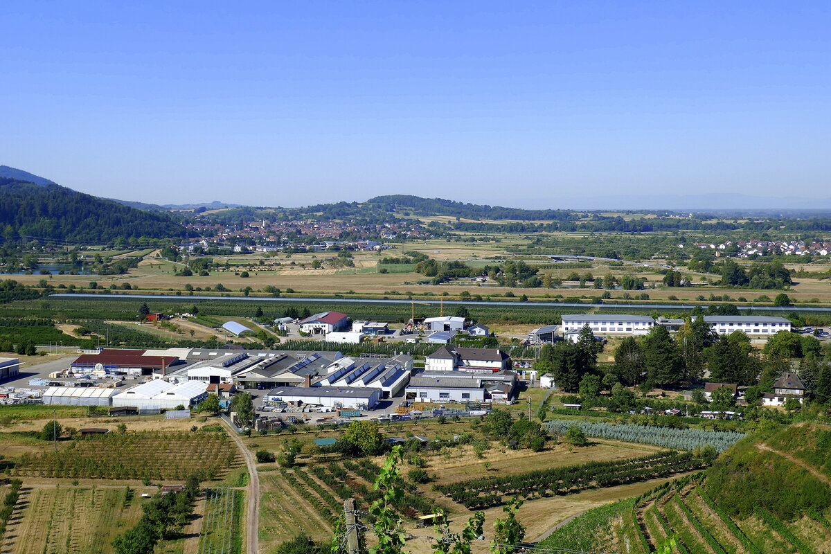 Ortenberg, Blick vom Schlo Ortenburg nach Sd-West auf das Gewerbegebiet, dahinter wie ein Strich in der Landschaft die kanalisierte Kinzig, dahinter der Ort Elgersweier, Aug.2022