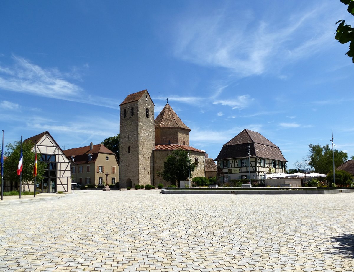 Ottmarsheim, Blick ber den neugestalteten Platz am Rathaus zur berhmten Abteikirche aus dem 11.Jahrhundert, Juli 2017