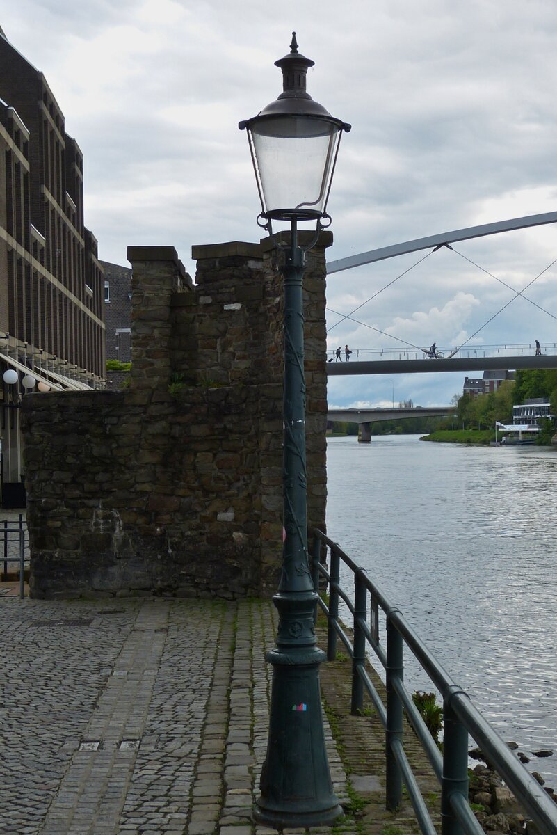 Schne alte Straenlaterne nahe dem Rest der alten Stadtmauer am rechten Flussufer in Maastricht. 05.2023 