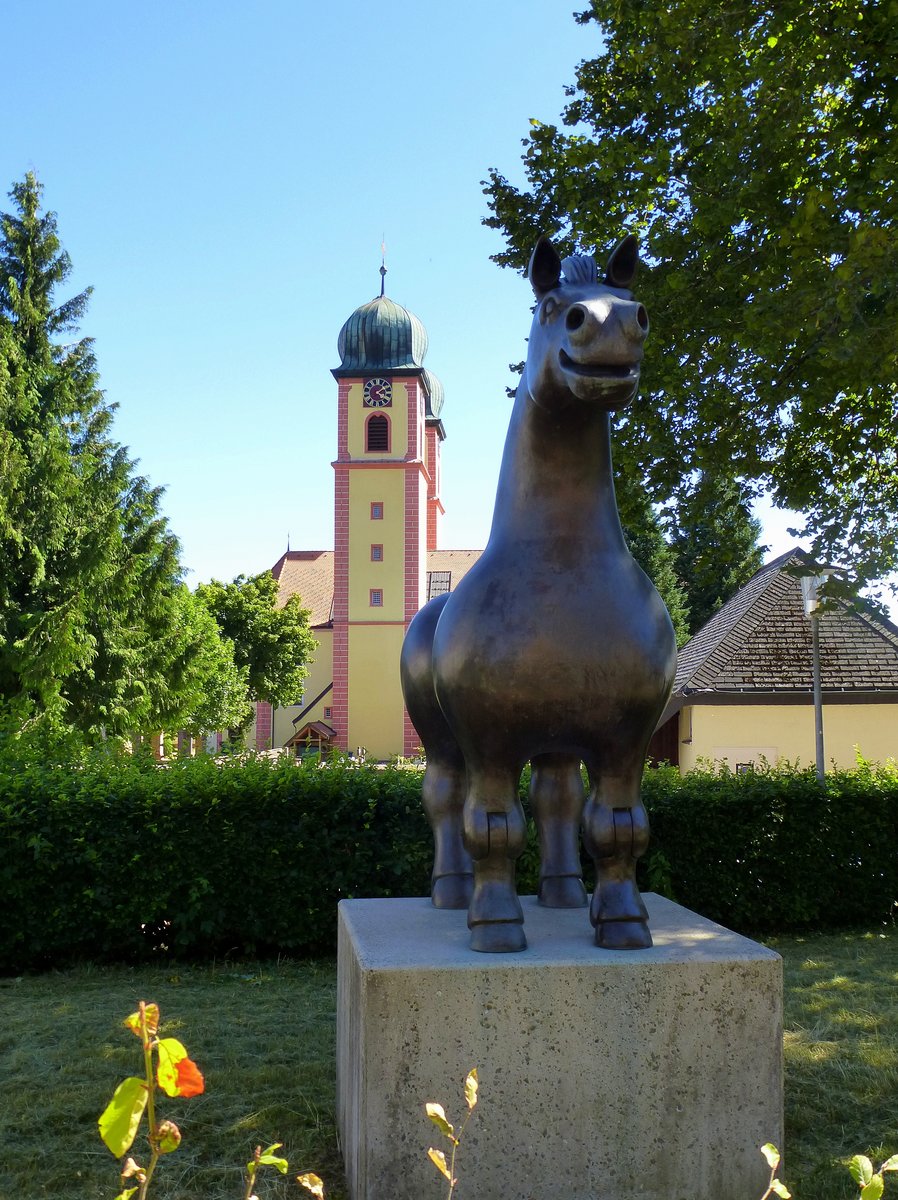 St.Mrgen, die Bronzeskulptur  Groes Ross  von Franz Gutmann erinnert an die Tradition der Pferdezucht im Ort, dahinter die ehemalige Klosterkirche, Juli 2015