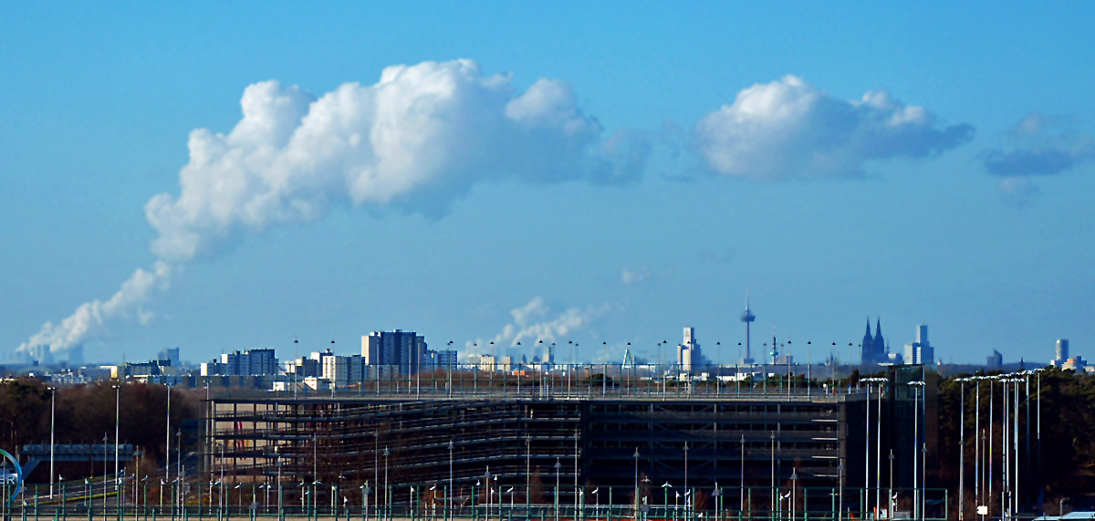 Vom Flughafen Kln aus die Skyline von Kln mit Fernsehturm und Dom und darber die RWE-Kraftwerkwolken - 02.02.2014