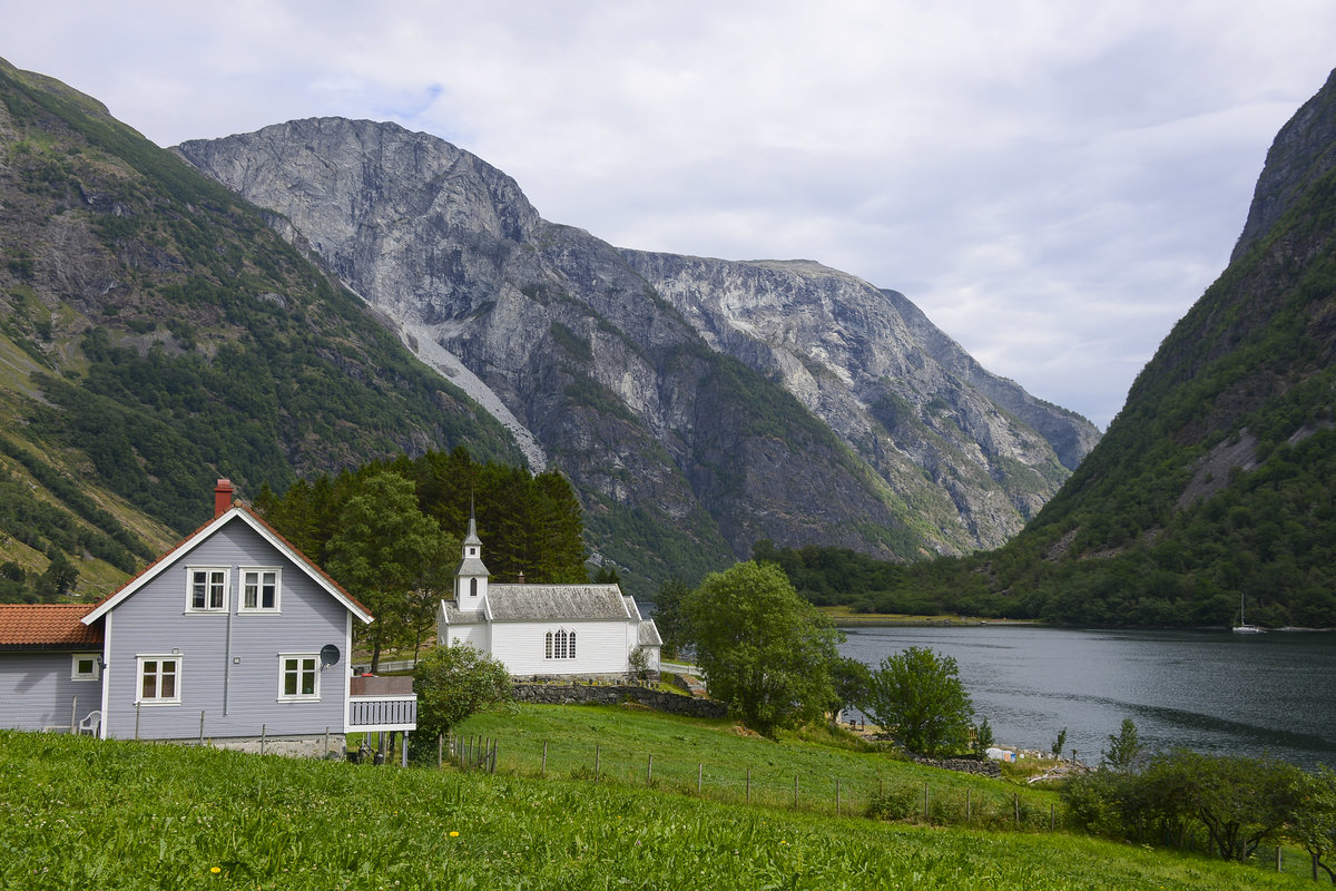 Wohnhaus und Kirche im Dorf Bakka an der Nryfjorden i Norwegen. Aufnahme: 15. Juli 2018.