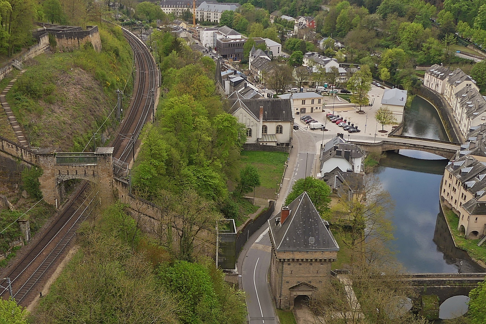 Blick von der Roten Brcke auf das Pfaffentahl mit einem Vauban Turm und der Bahnstrecke vom Bahnhof in Luxemburg in Richtung Troisvierges, (Linie 10) am rechten Flussufer der Alzette. 04.2024

