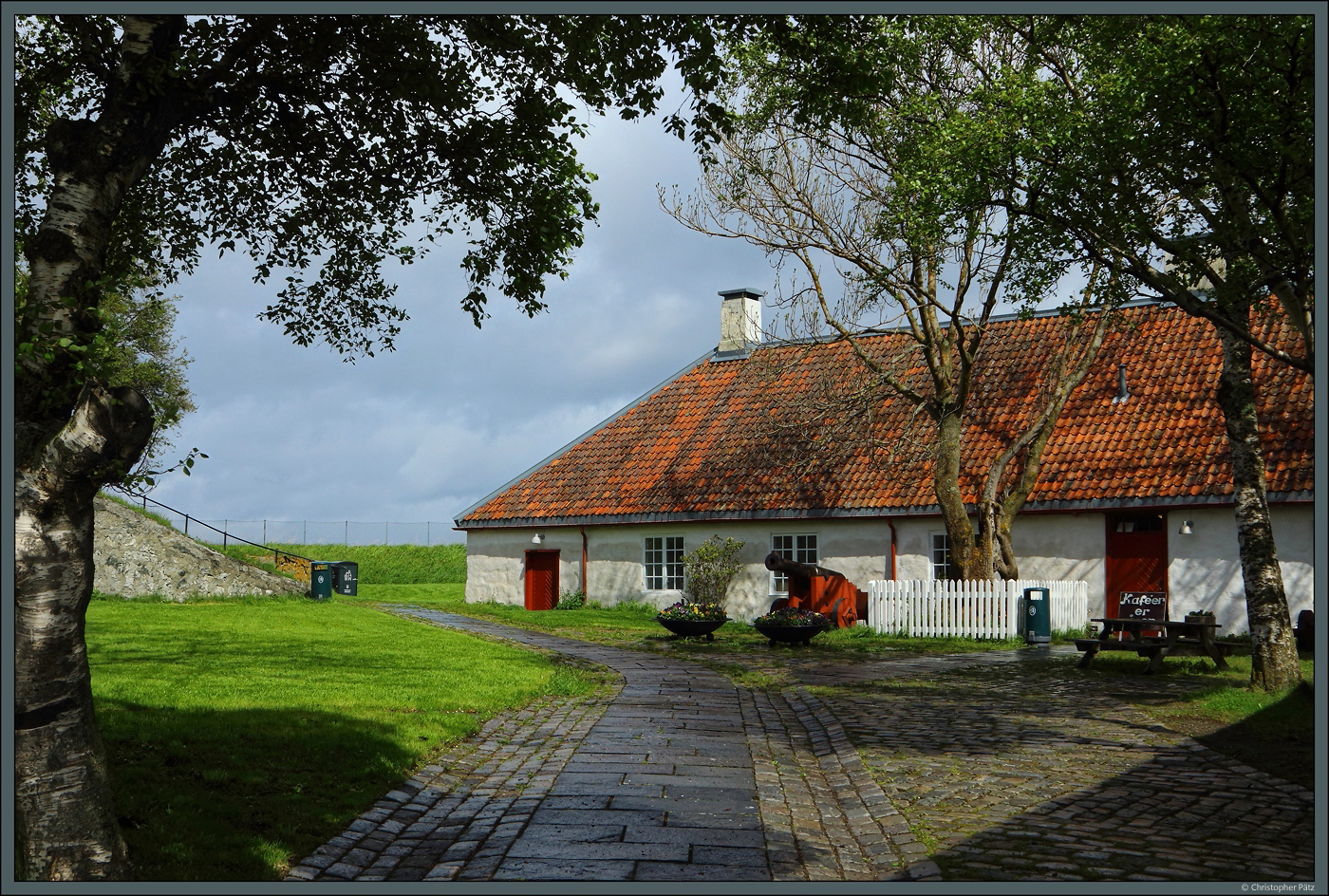 Das Haus des Kommandanten auf der Insel Munkholmen beherbergt heute ein kleines Restaurant. Davor sind alte Geschtze aufgestellt. (Trondheim, 25.05.2023)