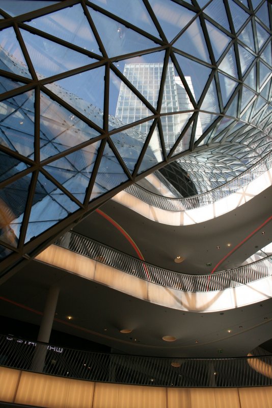 Blick von einer der unteren Etagen der Zeil Galerie durch den  Glaswurm  nach oben auf zwei Hochhuser.
