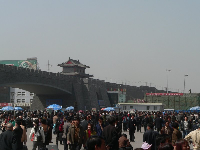 Der Bahnhofsvorplatz und die Stadtmauer in Xi'an. Der Zugverkehr in China transportiert gewaltige Menschenmengen. Es bestehen bequeme und moderne Nachtverbindungen zwischen den groen Orten. April 2006