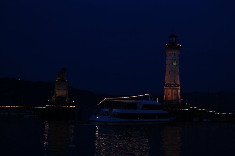 Die Lindauer Hafeneinfahrt zu spter Stunde. Faszinierend ist das Lichterspiel der vorbeifahrenden Schiffe und dem beleucheteten Turm