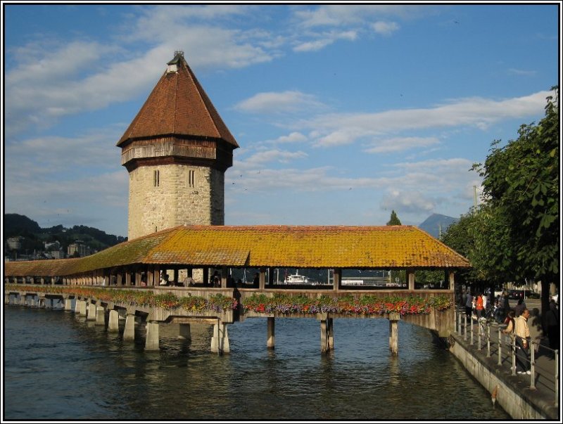 Die unvermeidbare Kapellbrcke mit dem Wasserturm in Luzern, aufgenommen im Abendlicht am 22.07.2007.