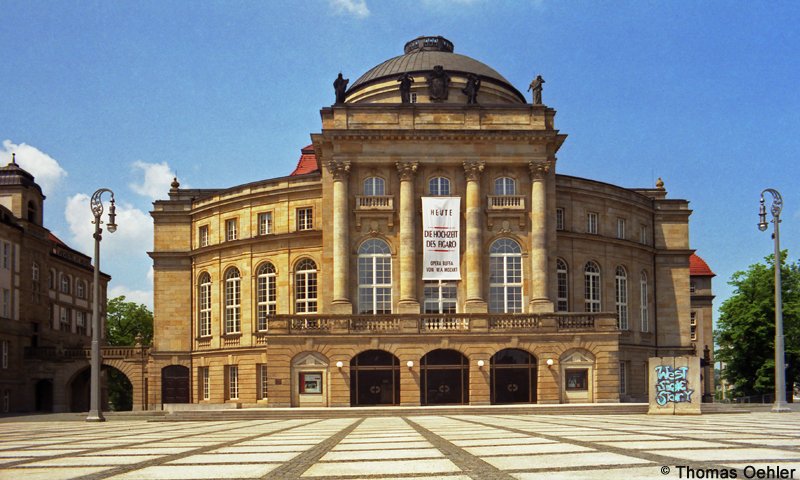 Diese Aufnahme von 1996 zeigt das Chemnitzer Opernhaus auf dem Theaterplatz. Es wurde von Ferdinand Richard Mbius entworfen und entstand im Zeitraum von 1906 bis 1909. Im 2. Weltkrieg zerstrt, wurde es danach wieder aufgebaut und noch zu DDR-Zeiten begann eine umfassende Sanierung. Heute bildet es zusammen mit der benachbarten Petrikirche und dem Knig-Albert-Museum das historische Herz der Chemnitzer Innenstadt.