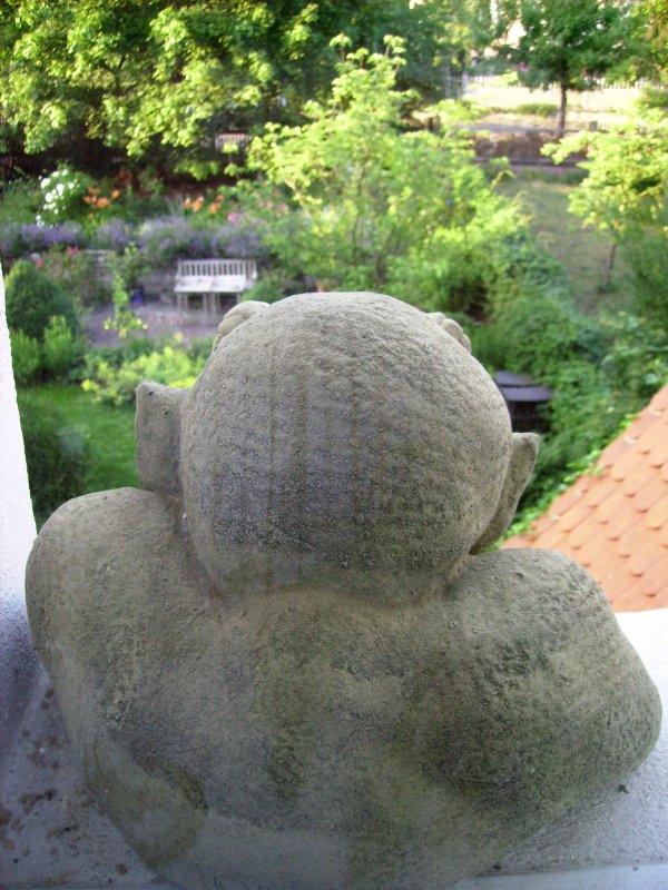 Dieser steinerne Gargoyle sitzt in einer Stadtmauernische und schaut von unserem Wohnzimmerfenster auf den Teil des Gartens, der sich im ehemaligen Stadtgrabenbereich befindet. Direkt ber dem Kopf erkennt man einen Teil der Terrasse.