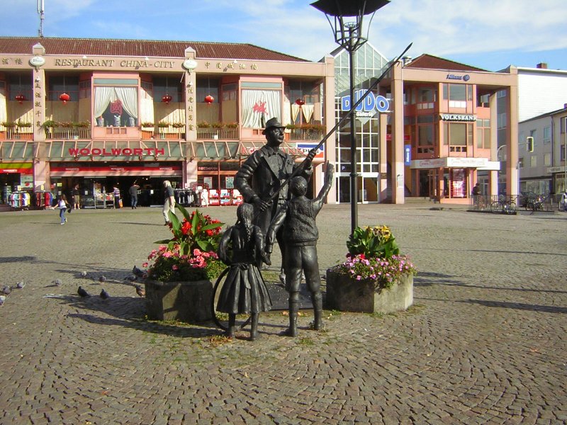 Dieses Foto zeigt:  De Monn mit de long Stong  -un zwei Dudwiller Kinner-
Nheres kann man auf dem Foto erkennen ( Eiserne Tafel ID 16484 .)Das Foto wurde auf dem Dudweiler Dudoplatz im Saarland aufgenommen.