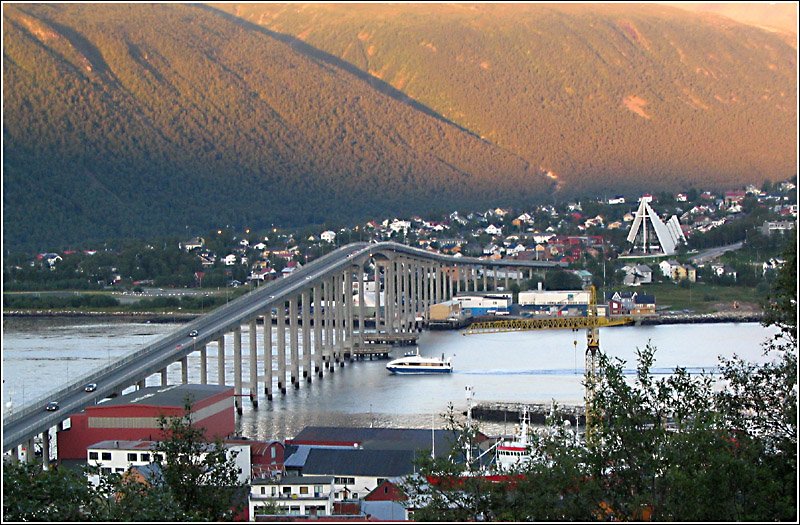 Europas grte Stadt am 9. August 2006 um 21:30 Uhr mit den beiden Wahrzeichen, der Brcke ber dem Tromssundet und der Eismeerkathedrale. Die tiefstehende Sonne bestrahlt nur noch die Berghnge. (Jonas)