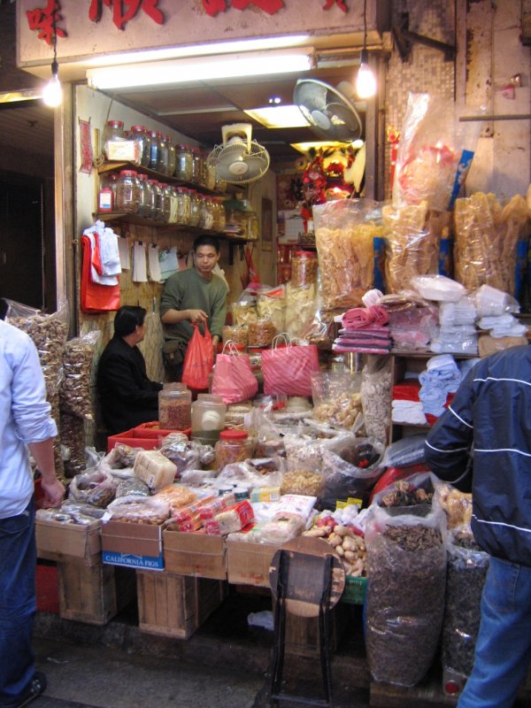 Hong Kong - Szenen auf einem Strassenmarkt zwischen Hopewell Center und Hennessy Rd. Soooo ein kleiner Laden und soooo viel Auswahl in  den Tten, Scken, Ksten und Dosen. Was wohl in den Glsern im Wandregal angeboten wird? 