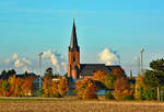 Kirche in Eu-Firmenich, im Hintergrund die Dampfwolken des RWE-Kohlekraftwerkes Weisweiler in ca.