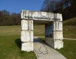 Lrrach, am Fue der Burgruine Rtteln steht das Portal  Dreilndereck  des Wander-Westweges Schwarzwald, Mrz 2015
