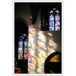 Das Sonnenlicht scheint durch die bunten Glasfenster in die Stiftskirche von Baden-Baden.