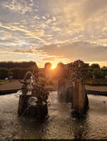 Nach einem Regenschauer zeigt sich der Neptunbrunnen in den Herrenhuser Grten von Hannover im Sonnenuntergang.