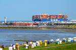 Der Containerfrachter HMM Southampton ist auf dem Weg von Hamburg nach Tanger in Marokko und passiert den Strand und die Hafenanlage in Cuxhaven Grimmelshrn.