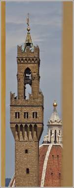 Blick durch eine kleine Mauerlcke auf die Wahrzeichen von Florenz: Die Kuppel von Dom Santa Maria del Fiore und den Turm des Palazzo Vecchio.