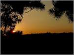 Am Abend liegt die Ortschaft Noertrange im Gegenlicht des Sonnenuntergangs, wenn man in Wiltz auf der Anhhe  op Baessent  steht.