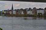 Blick vom linken Maas Ufer unter der Fugngerbrcke hindurch, auf die Uferpromenade auf der rechten Flussseite in Maastricht.