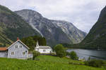 Wohnhaus und Kirche im Dorf Bakka an der Nryfjorden i Norwegen.