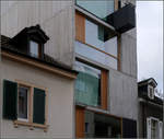 Moderne Architektur in Basel -    hnlich schmal wie die beiden alten Nachbarhuser, aber deutlich hher, aus gnzlich anderem Material und in einer anderen Sprache steht das