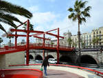 Eine rote Fugngerbrcke im Bereich des alten Stadthafens von Barcelona.