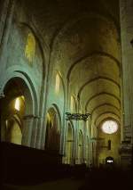 Spanien Poblet, Monestir de Santa Maria, katalanisches Zisterzienserkloster. Bau 12.-15. Jh., Innenraum romanisch. Mittelschiff nach Westen, s�dliches Seitenschiff sichtbar. Spitztonnengew�lbe. 2-zoniger Wandaufbau mit Arkaden und Obergaden. Hinten Westrose. Aufnahme von Juli 1994, HQ-Scan ab Dia.
