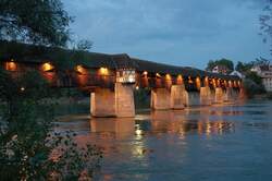 Holzbrcke - Die Lichter der 400 Jahre alten Brcke, nach Plnen des bekannten Brckenbaumeisters Blasius Baldischwiler, spiegeln sich im ruhigen Wasser des Rheins.