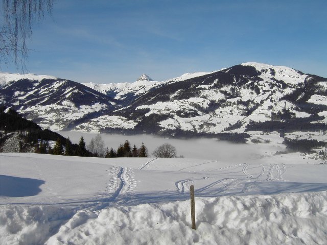 Whrend in 1200 Meter Hhe die Sonne scheint, liegen das Tal und Hollersbach unter dichtem Nebel. Das Bild entstand an einem Morgen im Januar vor dem Hollersbacher Berghotel  Berghof 
