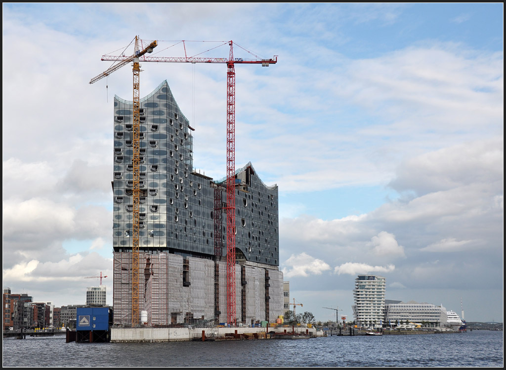 . Gro und teuer - die neue Elbphilharmonie in Hamburg. Neben dem Konzertsaal entstehen hier auch Wohnungen und ein Hotel. Hinter den Mauern des alten Speichergebude befindet sich das Parkhaus. Architekten: Herzog und de Meuron (Basel). Im Hintergrund rechts der Marco-Polo-Wohnturm und das neue Unilever-Gebude, beide von Behnisch Architekten (Stuttgart). August 2011 (Jonas)