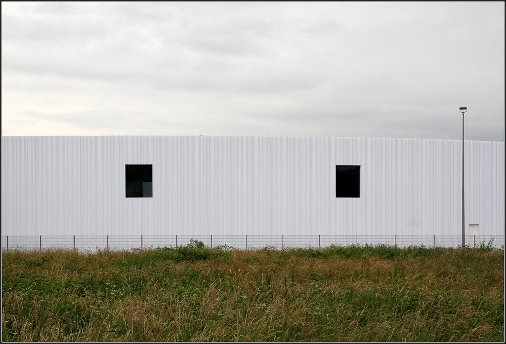 . Groer Rundbau - Die Fassade wird dort wo keine Tore fr die LKWs sind, durch fast quadratische Fensterffungen gegliedert. Vitra, Weil am Rhein, 20.06.2013 (Matthias)